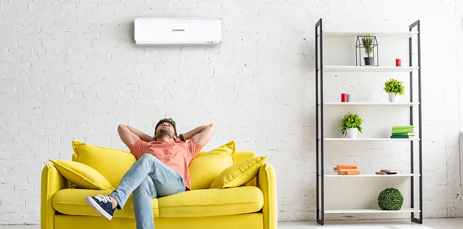 man sitting underneath mitsubishi heavy industries heat pump after setting the timer