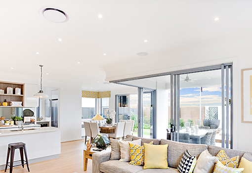 ducted heat pump system installed into a modern large living area within a home with grilles visible in ceiling